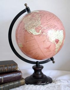 an old globe sits on top of three books