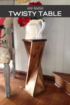 a vase with flowers in it sitting on top of a wooden table next to a chair