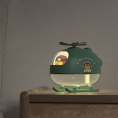 a green lamp sitting on top of a wooden table