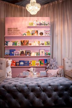 a room filled with lots of books and stuffed animals next to a wall mounted book shelf