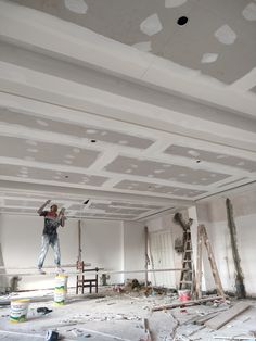 a man is painting the ceiling in an empty room