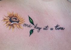 a sunflower with the words one day at a time written on it's chest