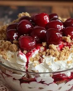 a close up of a dessert with cherries on top in a glass bowl,