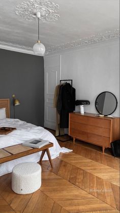 a bed room with a neatly made bed next to a wooden dresser and chest of drawers