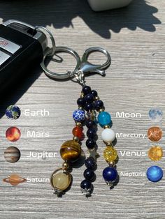 the solar system keychain is on top of a table with other planets around it