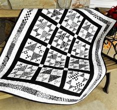 a black and white quilt sitting on top of a bench