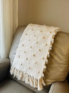 a white blanket sitting on top of a couch