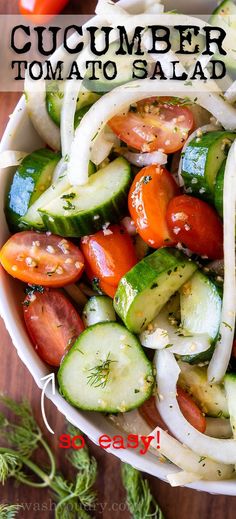 a salad with cucumbers, tomatoes, onions and herbs on it is ready to be eaten