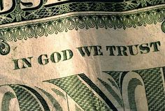 closeup of one dollar bill with the word god we trust written on it