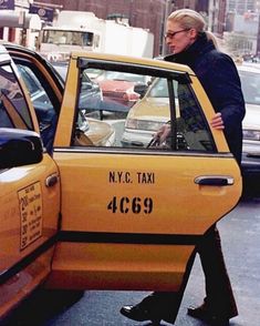 a woman walking past a taxi cab in new york city