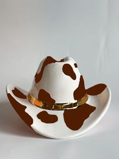 a white and brown cow print cowboy hat