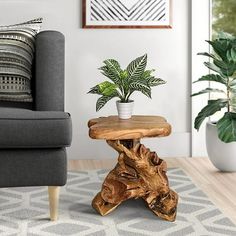 a wooden table with a potted plant on it in front of a gray couch