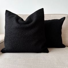 two black pillows sitting on top of a couch