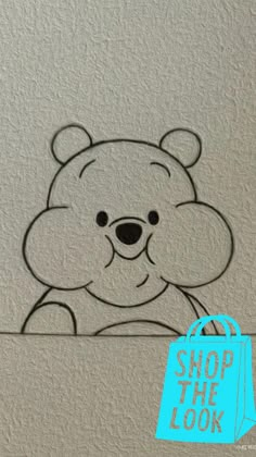 a drawing of a teddy bear on a white wall with black outline and the shape of a face