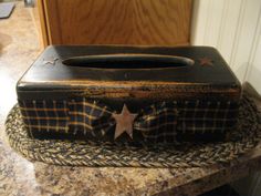 a wooden box with a star on it sitting on top of a granite countertop