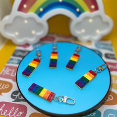 four pieces of rainbow colored legos are on a blue plate with a white cloud in the background