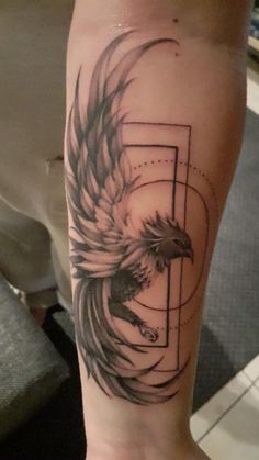 a tattoo on the leg of a person with an eagle and geometric shapes in it