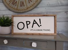 there is a sign that says opa it's a great thing next to a potted plant