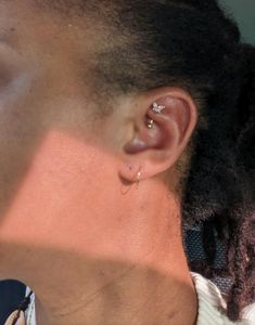 a close up of a person's ear and nose with piercings on it