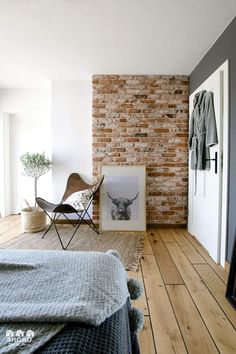 a bedroom with a brick wall and wooden floors