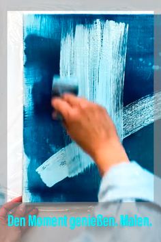 a person is painting on the wall with blue paint