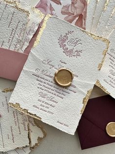 wedding stationery and envelopes are laid out on top of each other with gold foil