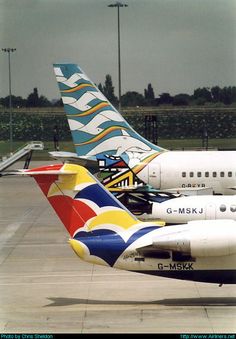 three airplanes parked on the tarmac at an airport with cloudy skies in the background