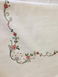 a white sheet with red flowers and vines on it