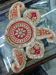 a red and gold broochi with intricate designs on display in a glass case