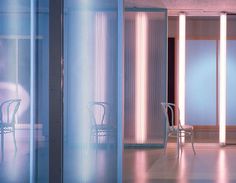 an empty chair and table in a room with tall white columns on either side of the wall