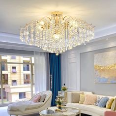 a living room filled with furniture and a chandelier hanging over the top of it