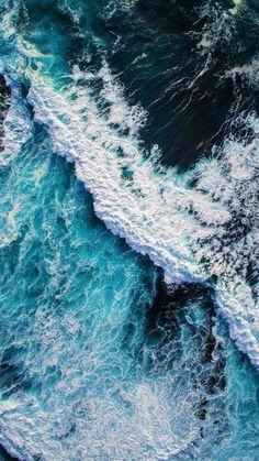 an aerial view of the ocean waves and foamy blue water, taken from above