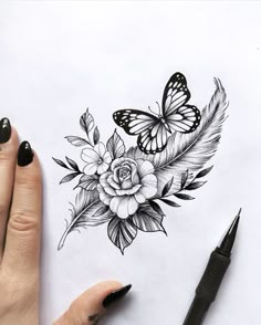 a woman's hand holding a pen next to a drawing of flowers and butterflies