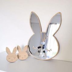 a mirror and some wooden bunny ears on a shelf