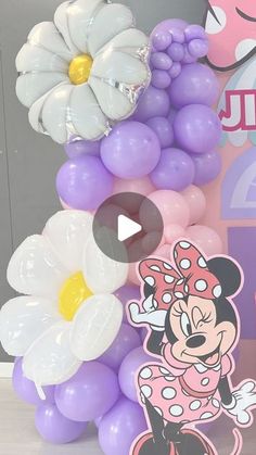 the balloon tower is decorated with minnie mouse balloons and daisies for an adorable birthday party