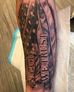 a man's arm with an american flag and words on it