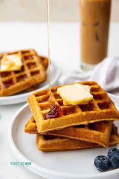 waffles with butter and blueberries on a white plate