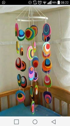 a mobile made out of paper circles hanging from a crib