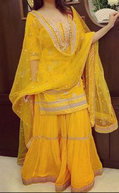 a woman in a yellow outfit posing for the camera