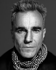 a black and white photo of a man with short hair wearing a scarf around his neck