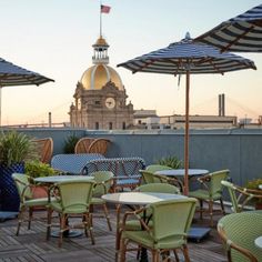 tables and chairs with umbrellas on top of a roof