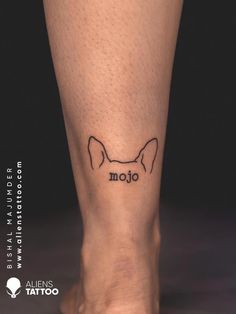 a person with a dog's head tattooed on their leg and the word mojo written in black ink