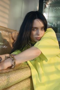 a woman sitting on top of a yellow couch