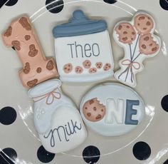 three decorated cookies on top of a plate with polka dot paper around them and the words they are made out of