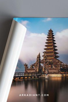 the book is opened to show an image of a pagoda in water with mountains in the background