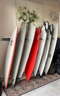 several surfboards are lined up against the wall