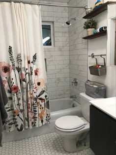 a white toilet sitting next to a bath tub in a bathroom under a shower curtain