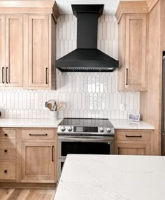 a kitchen with marble counter tops and wooden cabinets, along with an oven hood over the range