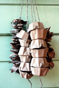 a bunch of brown paper wrapped in twine hanging from a hook on a green door