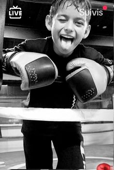 a young boy with boxing gloves on his hands